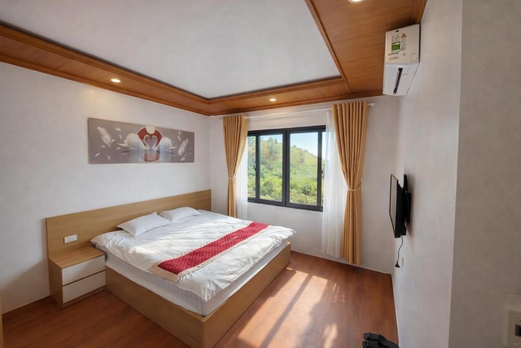 a bedroom with a large bed and a window at À Lôi Homestay Đồng Văn in Dồng Văn