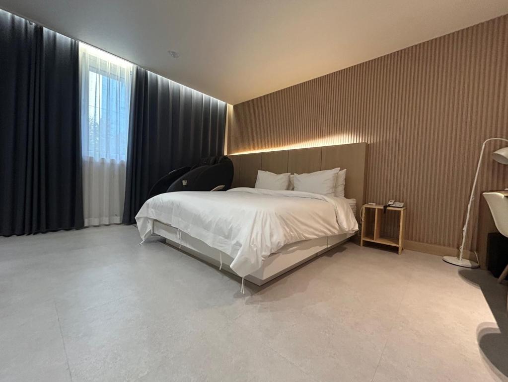 a hotel room with a bed and a window at 프라잇베리 호텔 in Chinhae
