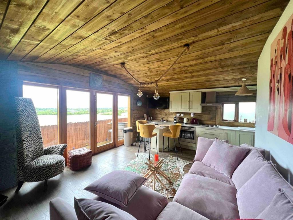 a living room with a purple couch and a kitchen at Dublin Seaview Cabin in Rathfarnham