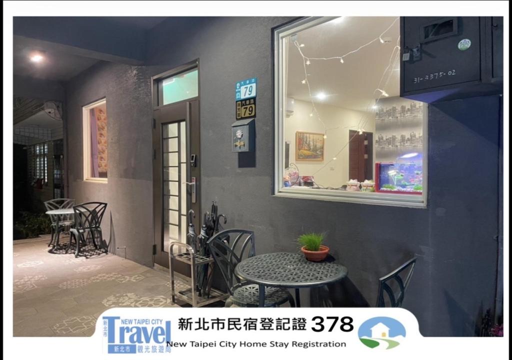 a window of a store with a table and chairs at Night Sea Homestay in Jiufen