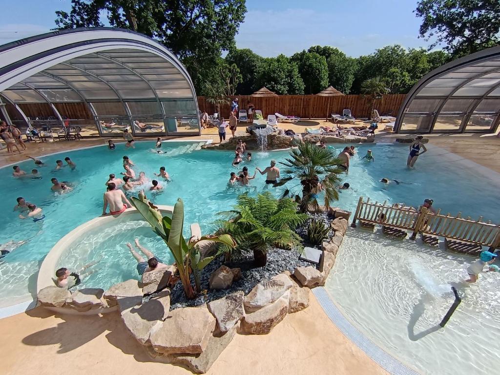 a group of people in a pool at a resort at Camping de La Hallerais Dinan in Taden