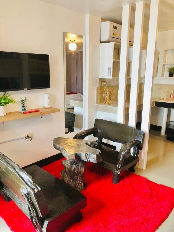 a living room with a chair and a red rug at JULIA'S PLACE HOTEL Dangcagan - Bukidnon in Dancagan