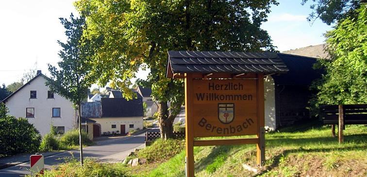 a sign on the side of a road with a building at Ferienhaus check ferien dot world in Berenbach
