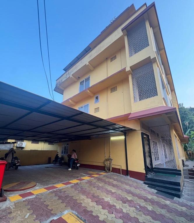 a building with a blue awning in front of it at Patkai Backpackers Hostel in Guwahati