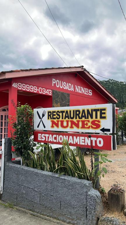a sign on the side of a red building at Pousada Nunes in Lauro Müller