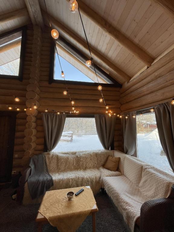 a living room with a white couch and a table at Nordic Log-House with Sauna in Valga