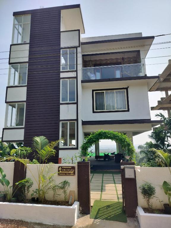 a large house with an arch in front of it at Vrindavan Homestay Panaji in Batim