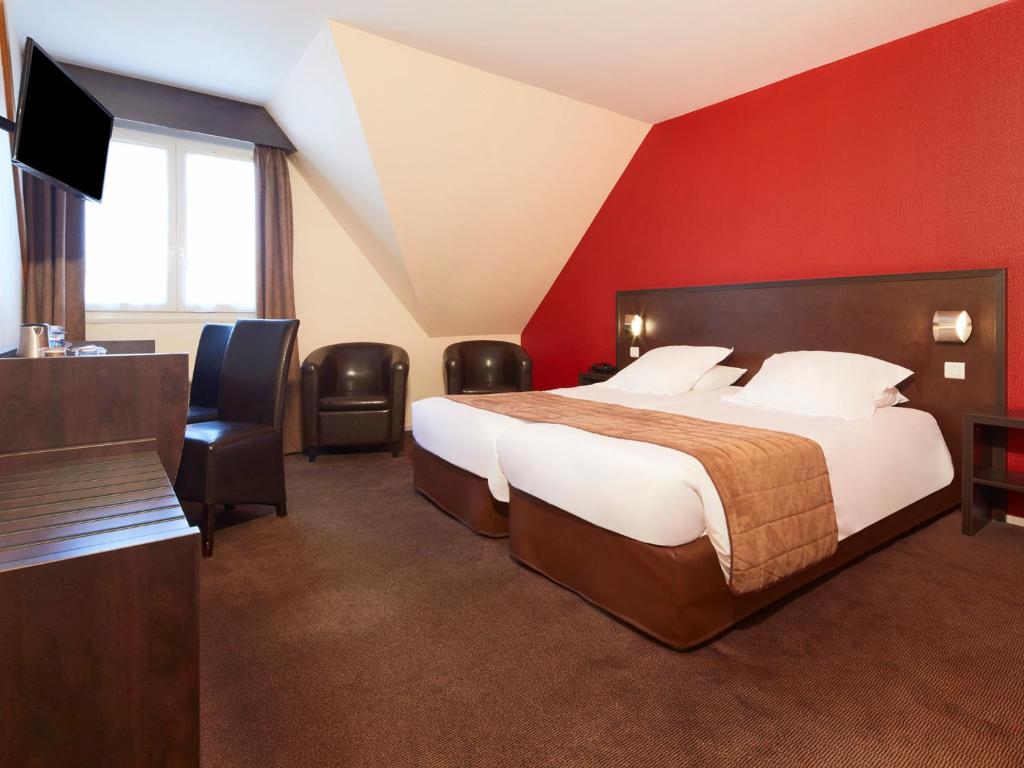 a hotel room with a bed and a flat screen tv at Kyriad Tours - Joué-Lès-Tours in Joue-les-Tours