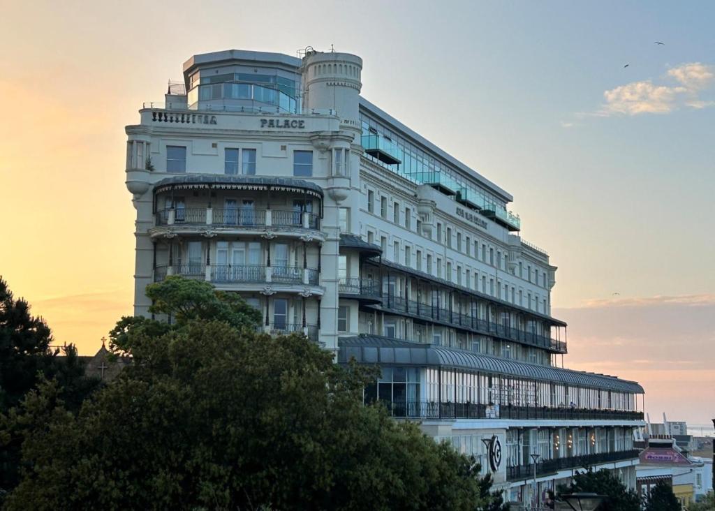 a tall white building with a sunset in the background at The Palace Hotel in Southend-on-Sea