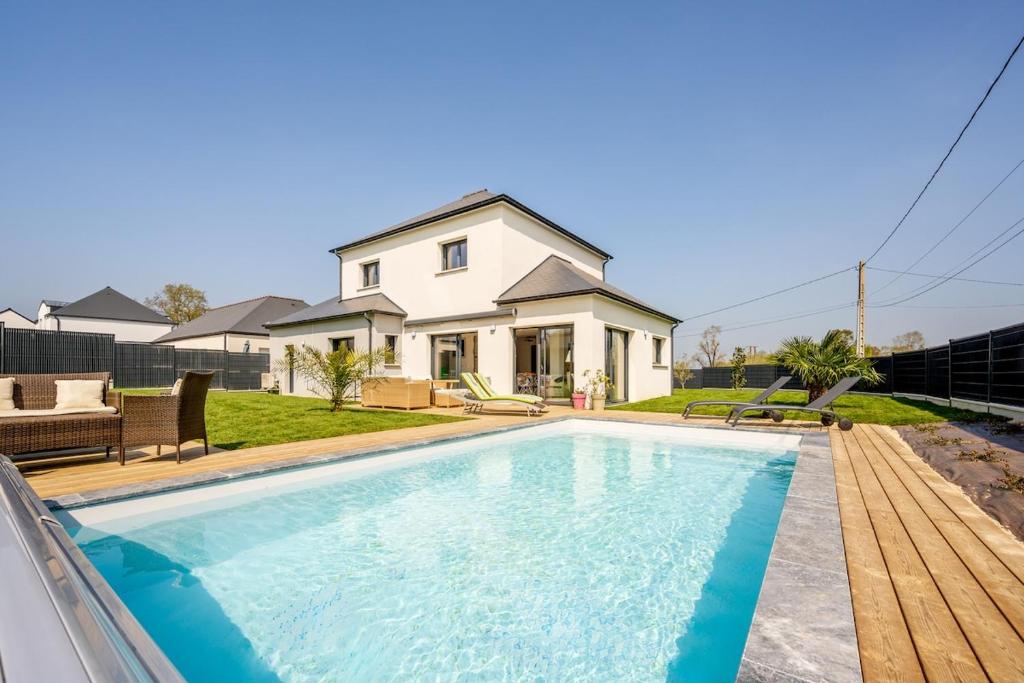 a swimming pool in front of a house at Le Clos Carnonen, villa avec piscine in Quessoy