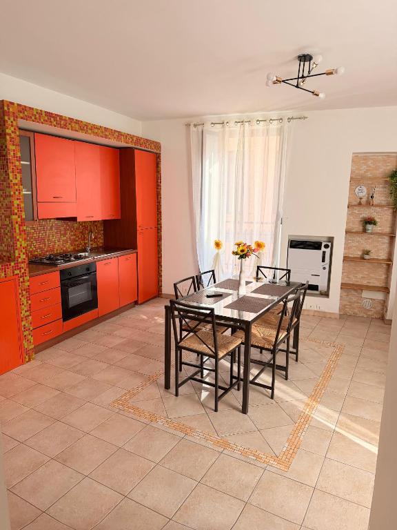a kitchen with a table with chairs and red cabinets at MARCONI APARTMENTS in Termoli