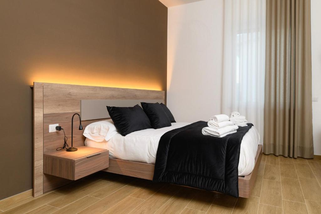ein Schlafzimmer mit einem großen Bett mit schwarzen Kissen in der Unterkunft L'Airone Resort - Soggiorno rilassante in Irpinia in Venticano
