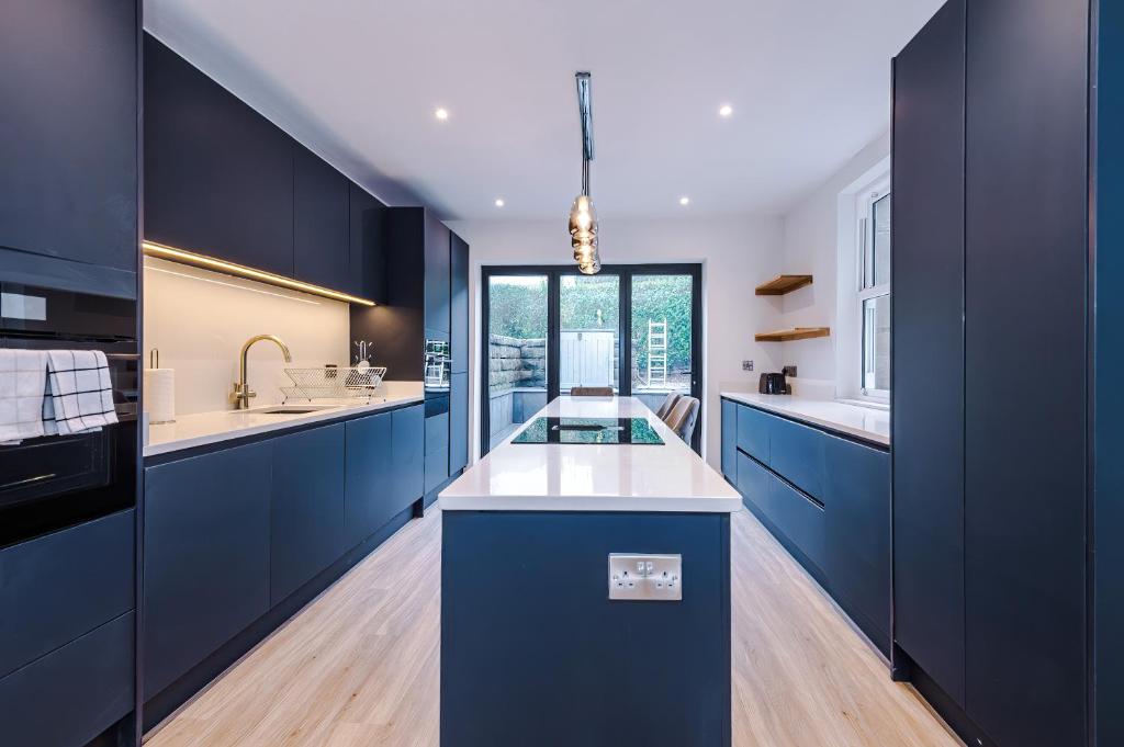 a kitchen with blue cabinets and a white counter top at Spring Mount - 3 Bedrooms - Close to Convention Centre in Harrogate
