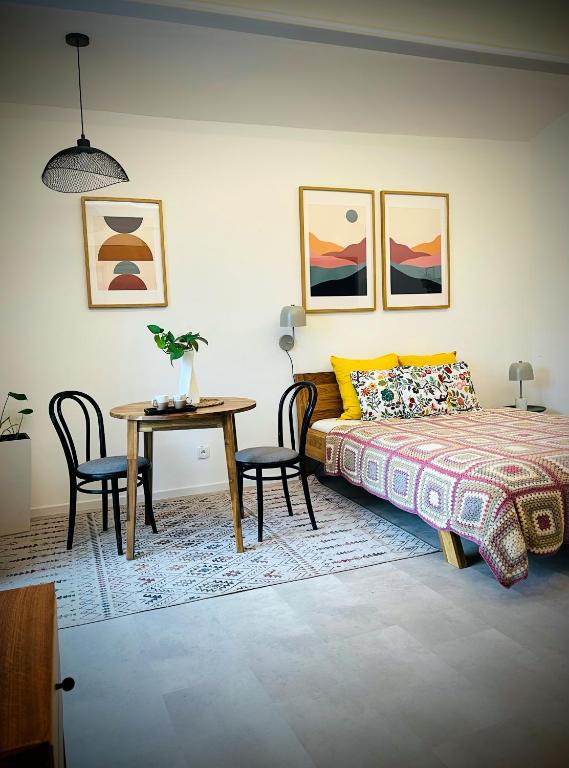 a bedroom with a bed and a table with chairs at In the nature in Vroutek