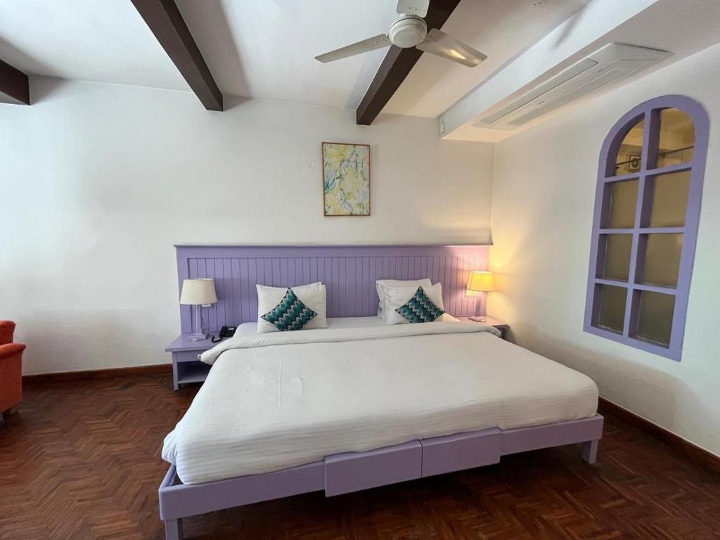 a bedroom with a large bed and a ceiling fan at Johnson Lodge Manali in Manāli