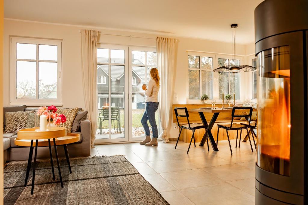 a woman standing in a living room looking out the window at Lieblingshof in Born