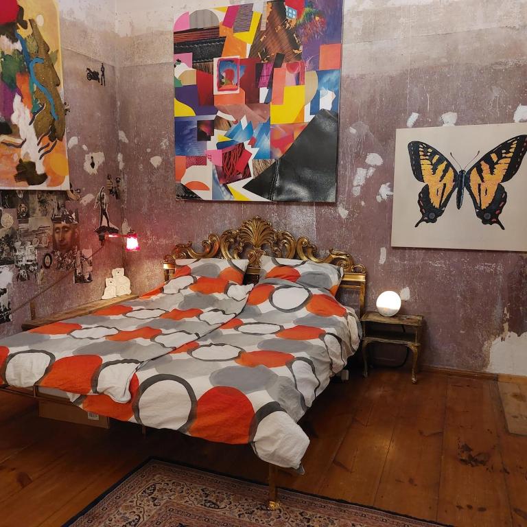 a bedroom with a bed and paintings on the wall at Crystal Ball Residency in Berlin