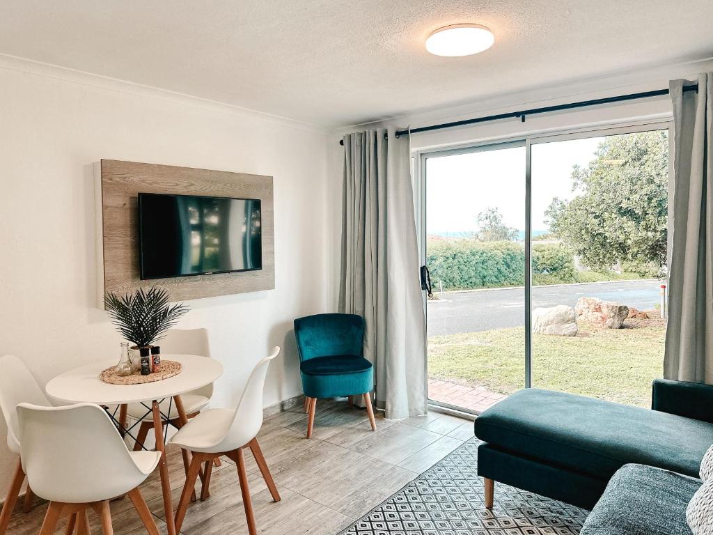 ein Wohnzimmer mit Sofa, Tisch und Stühlen in der Unterkunft Ebb & Flow in Hermanus