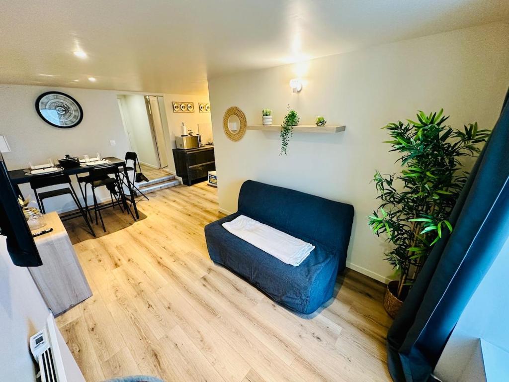 a living room with a blue couch and a table at Appartement moderne et chaleureux in Mutrécy