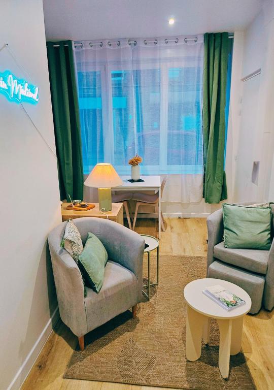 a living room with two chairs and a table at L'écrin médiéval in Fougères
