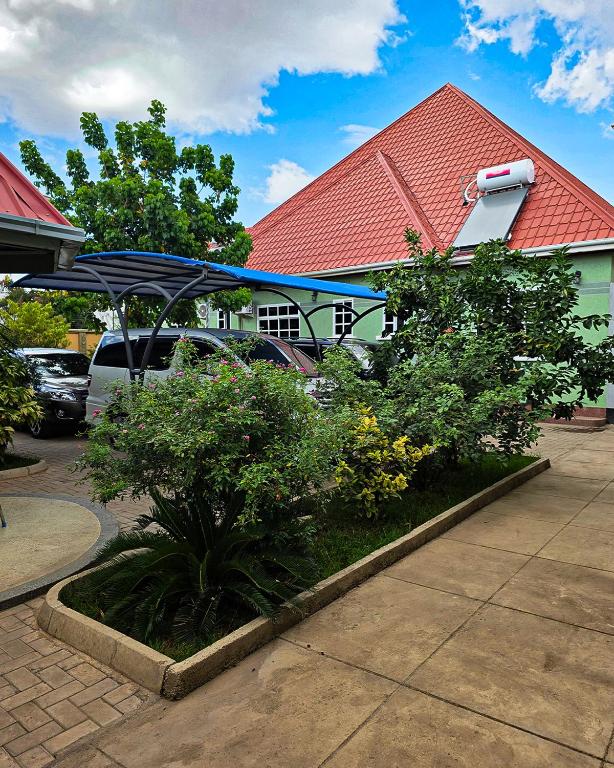 a house with a blue umbrella and some bushes at Kigongoni Gazella Hotel in Mto wa Mbu