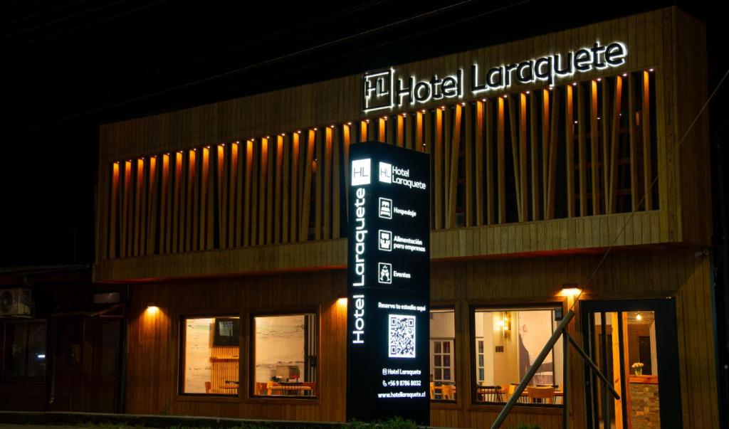 a building with a sign in front of it at night at Hotel Laraquete in Laraquete