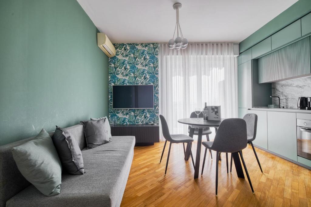 a living room with a couch and a table with chairs at Assago Forum Apt - 3 min Walk in Assago