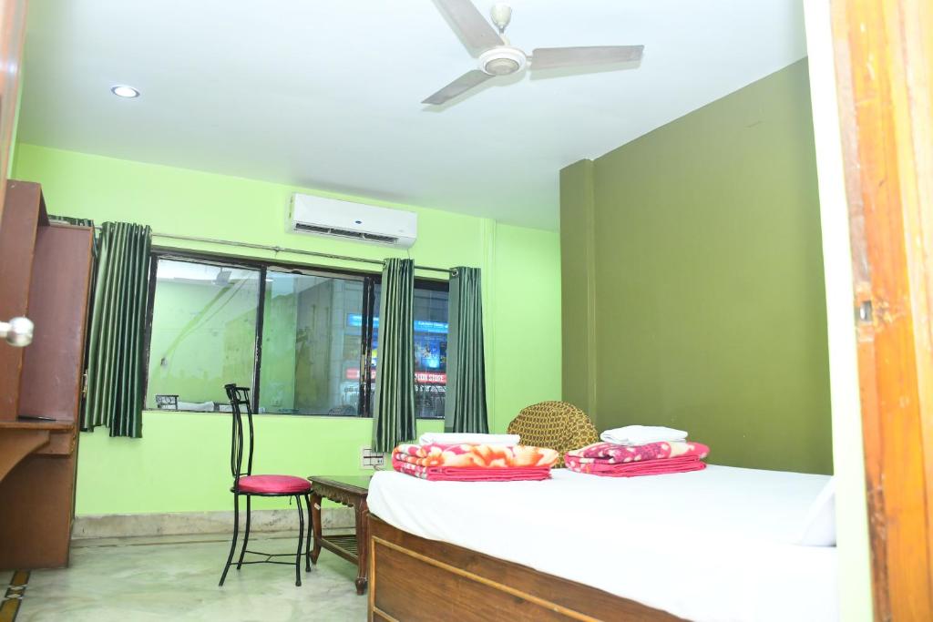 a room with a bed and a table and a window at Hotel Sampark in Bhadrak
