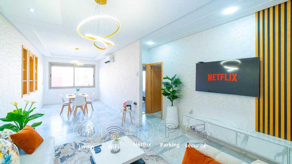 a living room with a sign on the wall at Familiale, raffinement et calme, entourée d'une vue sur le jardin - À proximité de l'aéroport et de Marjane in Fez