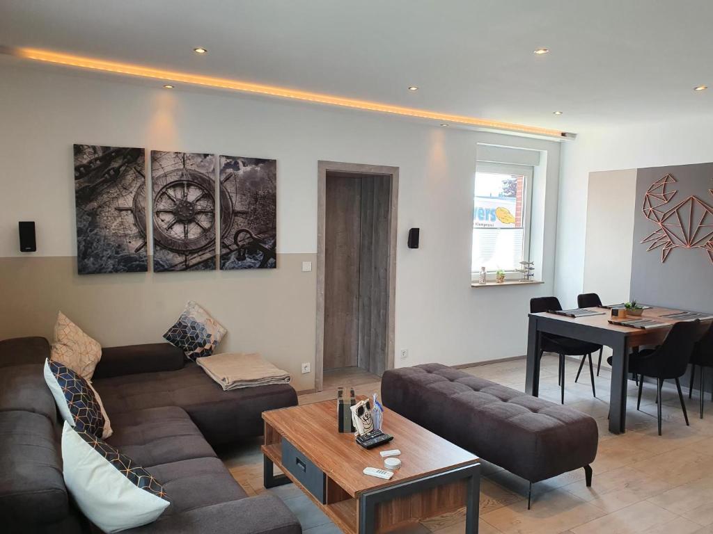 a living room with a couch and a table at Ferienhaus Wiesenpieper in Dornum