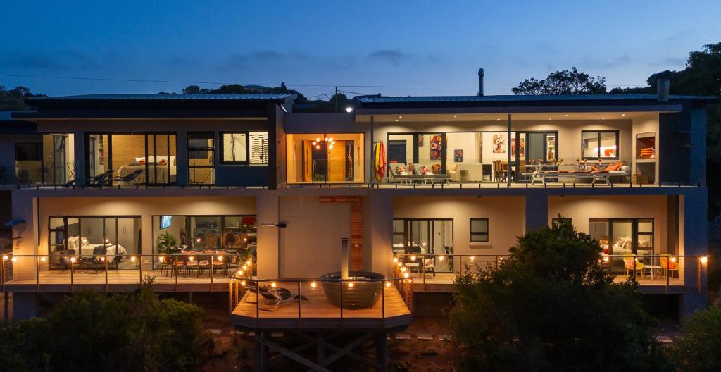 a large house with a lit up deck at night at SuPaViews in Wilderness