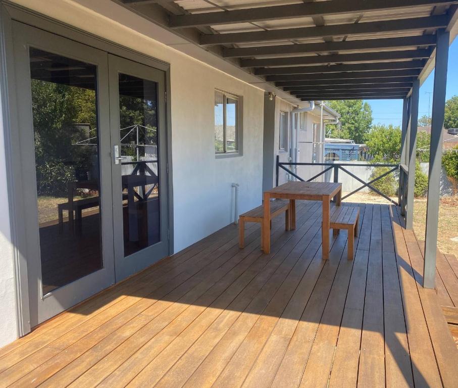 a wooden porch with a bench on a deck at Private 3Bed Home with Large Deck Central Location in Eaglehawk