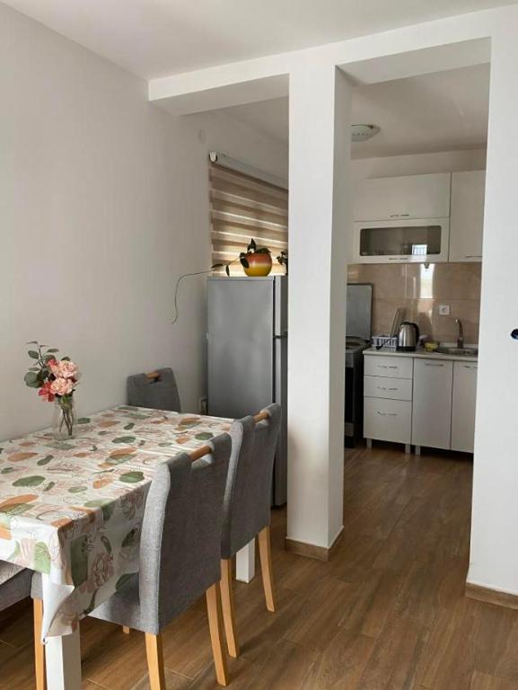a dining room table with chairs and a kitchen at Apartments Luna in Bar