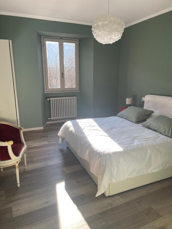 a bedroom with a large bed and a chandelier at Ca Sunder in Sondrio