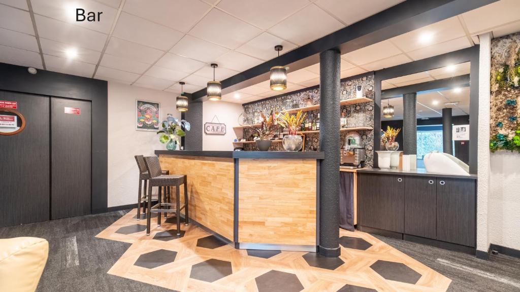 a bar in a restaurant with a counter and stools at Kyriad Direct Limoges Nord in Limoges