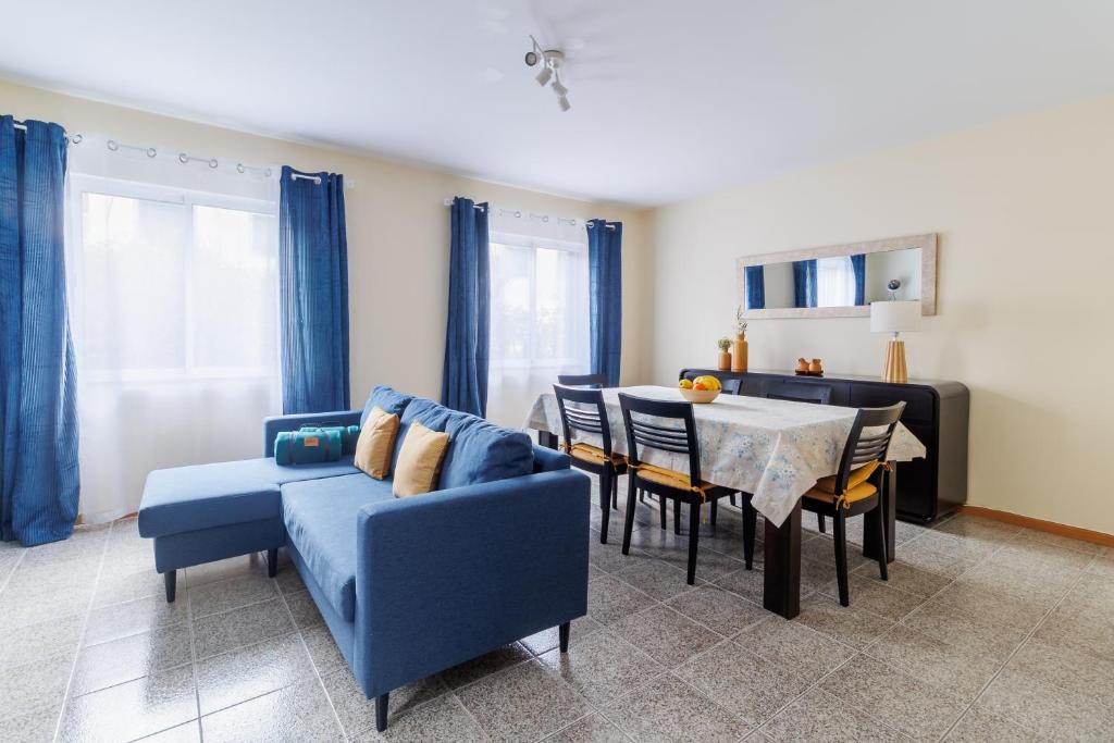 a living room with a blue couch and a table at Santana Lens & Trail House in Santana