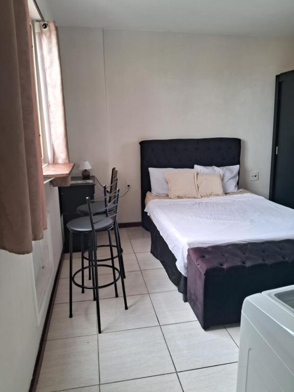 a bedroom with a bed and a table and chairs at Studio Playcenter in Campos dos Goytacazes
