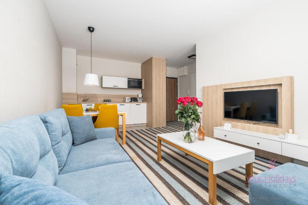 a living room with a blue couch and a table at Your Holidays Bel Mare II D105 in Międzyzdroje