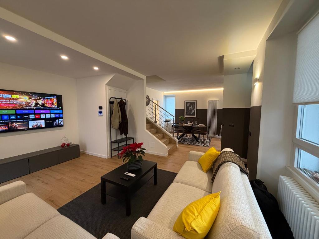 a living room with a couch and a flat screen tv at Foresteria Dambro rooms -2 Min walk to Bernina Express in Tirano