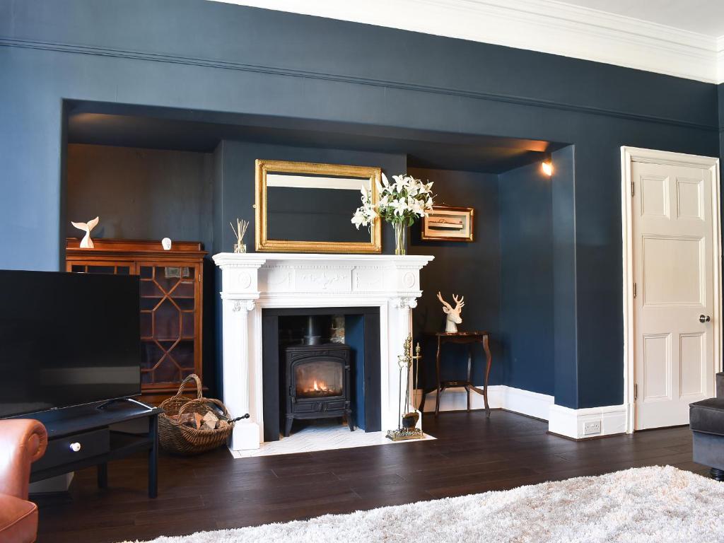a living room with a fireplace and a tv at Scarborough Esplanade in Scarborough