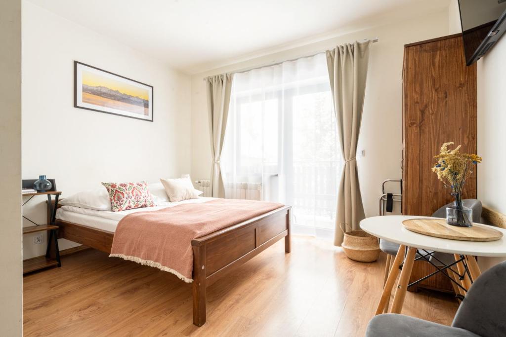 a bedroom with a bed and a large window at Pokoje u Kamińskich 26E in Zakopane