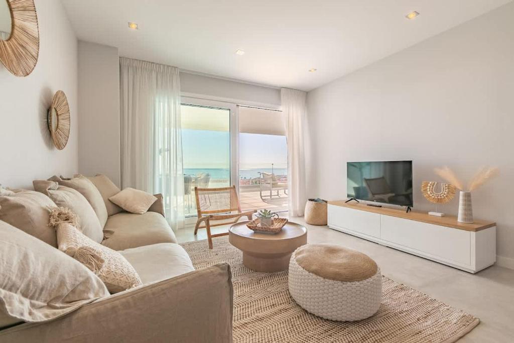 a living room with a couch and a flat screen tv at Doña Julia Sea Utopia in Casares