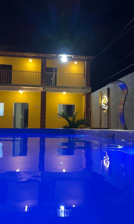a swimming pool in front of a house at night at Dunas Exclusive in Santo Amaro