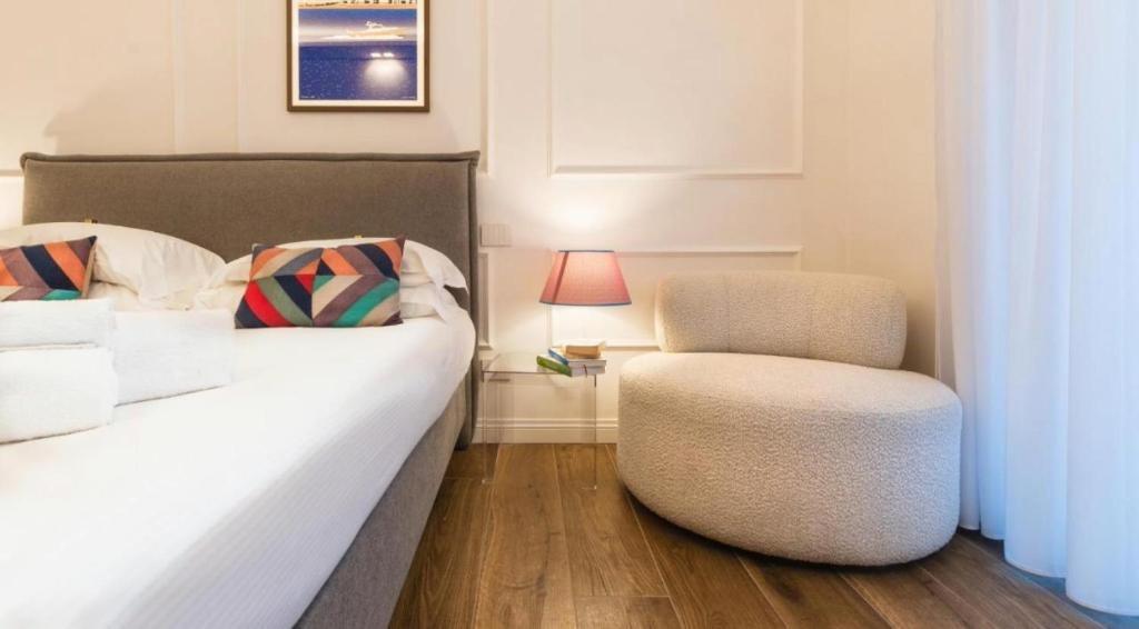 a bedroom with a bed and a chair at Riviera Suites - by Be Your Home in Civitavecchia