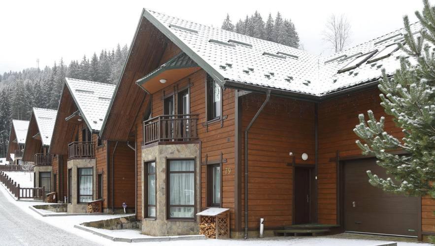 a row of wooden houses in the snow at Шале Вершина in Palyanytsya