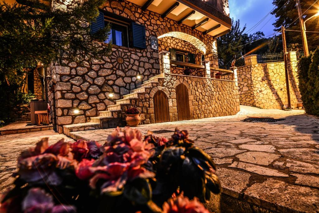 a house with a stone wall and a stone driveway at Camelia Suites in Synikia Mesi Trikalon