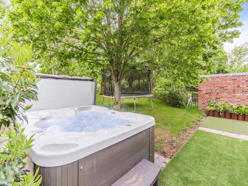 a hot tub in a yard with a tree at Willow Loft - Uk49479 in Bulmer