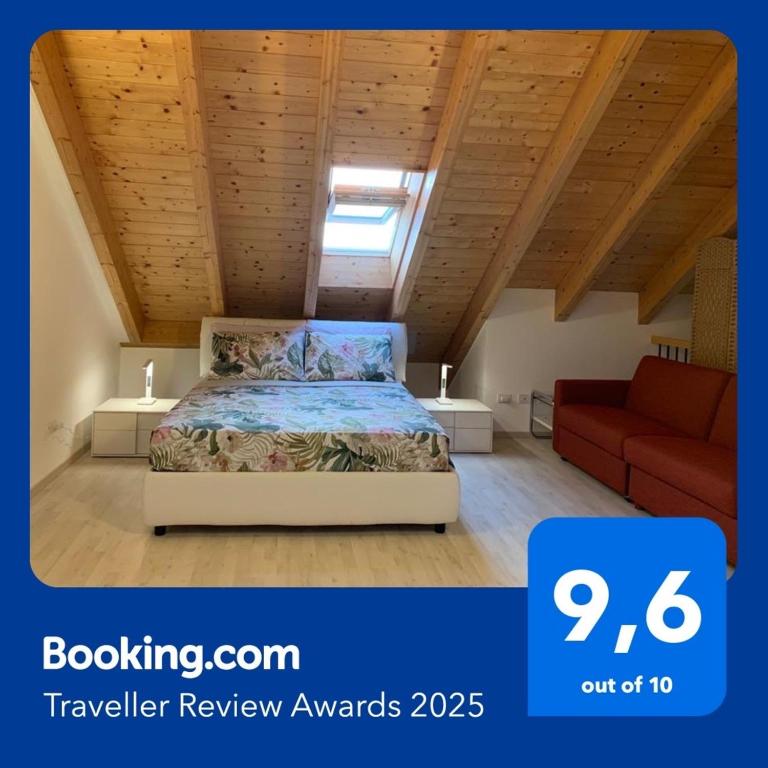 a bedroom with a bed and a red couch at Casa Vista Monte Rosa in Toceno