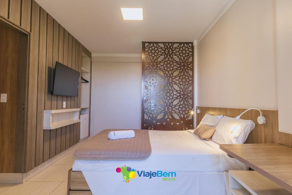 a hotel room with a bed and a tv at PIAZZA DIROMA FLATS PARA TEMPORADA in Caldas Novas
