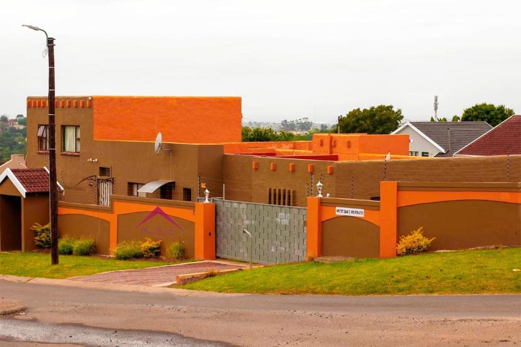 a house with an orange fence in front of it at Amazing Grace Inn BnB in East London